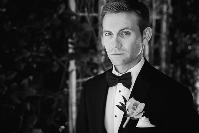 A black and white portrait of a man in a tuxedo