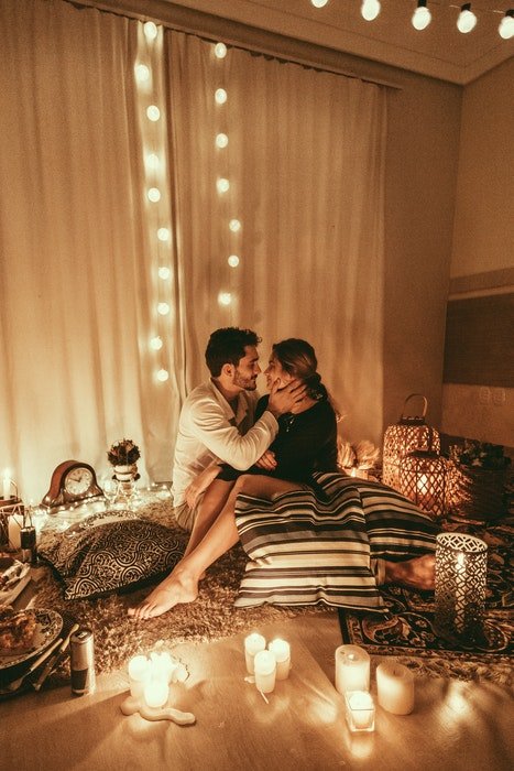 A couple embracing on a cosy bedroom floor