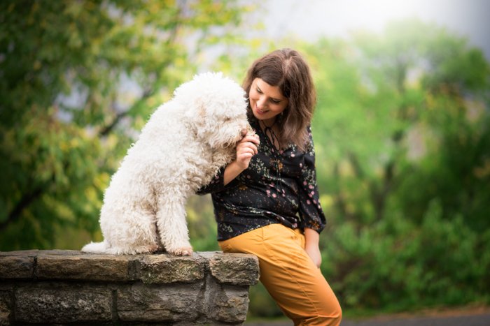 a woman photographed with her white dog in the park