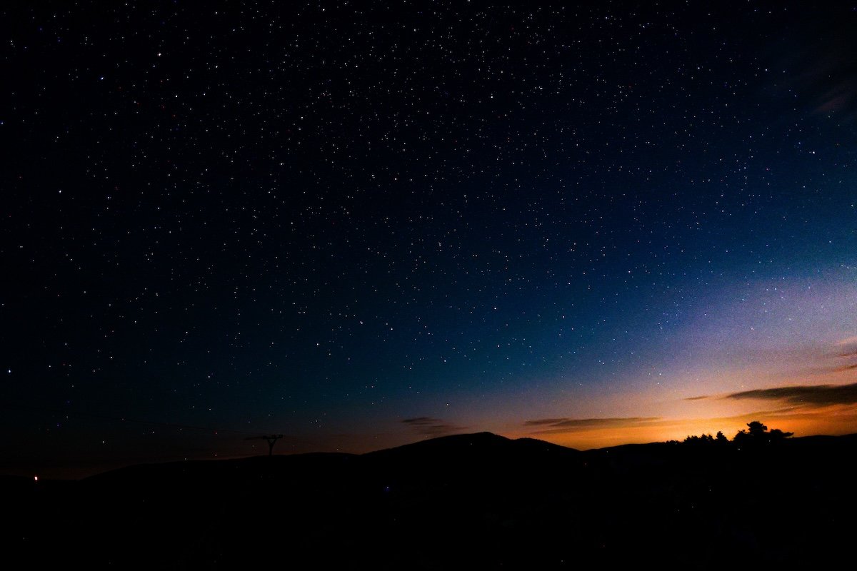 Landscape with a starry sky with the sun setting illustrating exposure in photography
