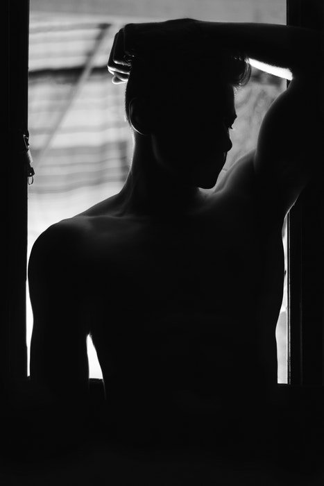 black and white photo of the silhouette of a male body