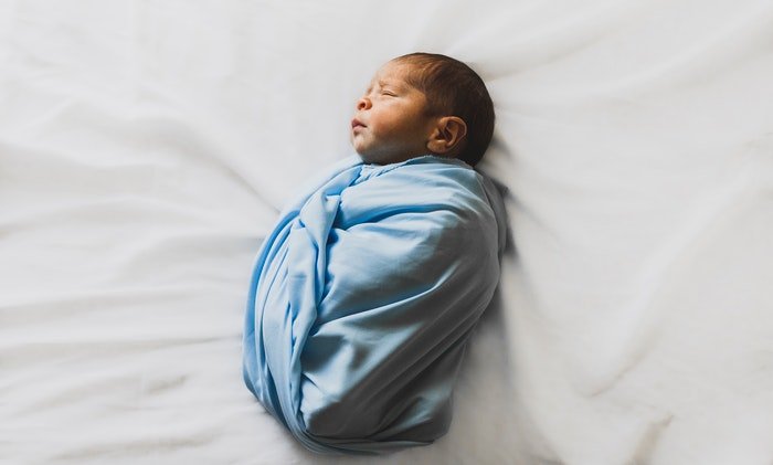 photo of a newborn in a small blue blanket