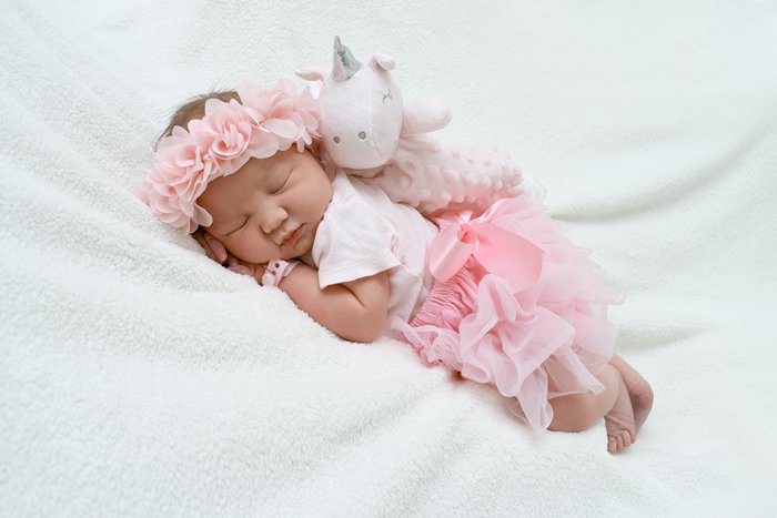 photo of a newborn baby in cute outfit posed with a teddy bear