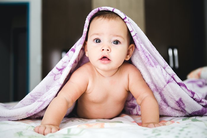 Cute newborn baby with a blanket on her head