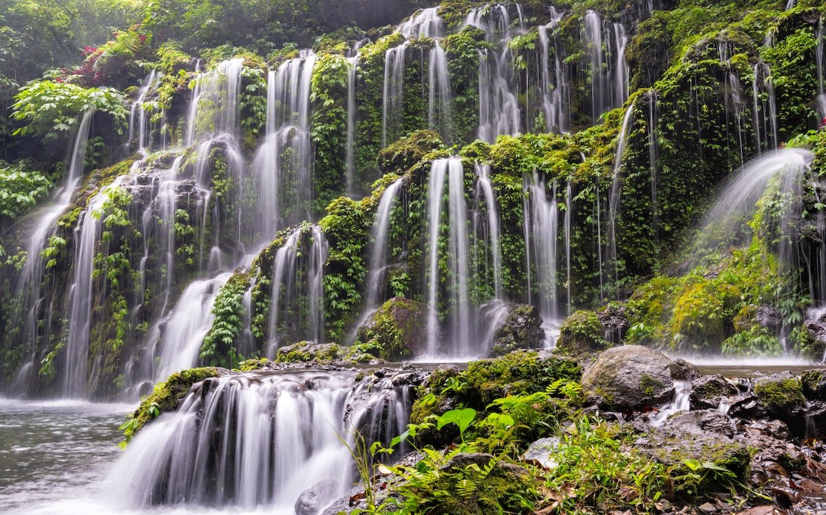 A landscape photo with multiple waterfalls taken with a slower shutter speed