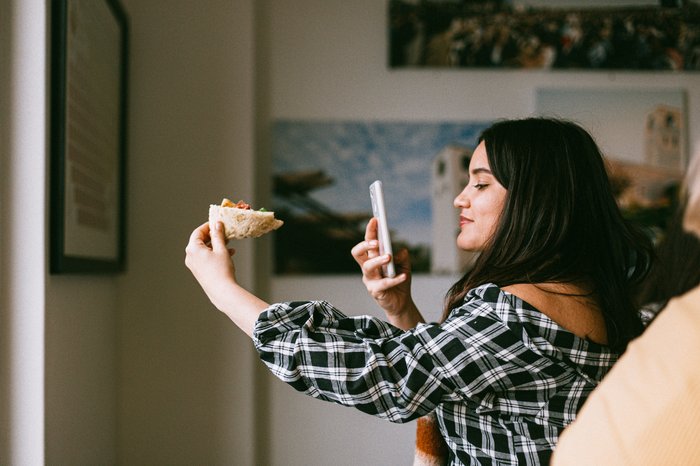 A girl taking a food photo with her smartphone