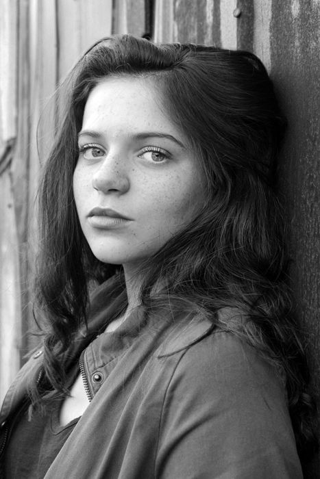 Black and white portrait of a girl against a wall