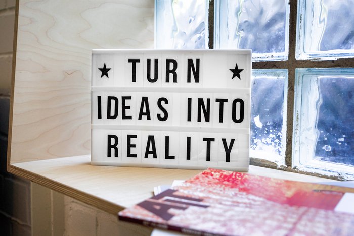 A cute sign saying 'turn ideas into reality' on a windowsill