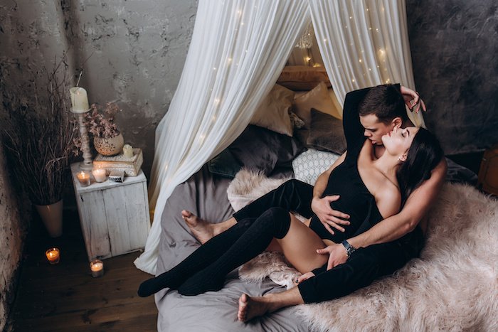 A couple posing together in bed for a boudoir photoshoot shot from above