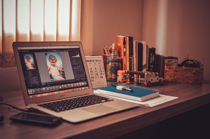 photo of a laptop on a desk by the window