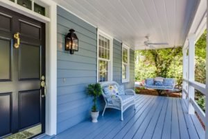 photo of a lovely porch with a blue sofa and a swing