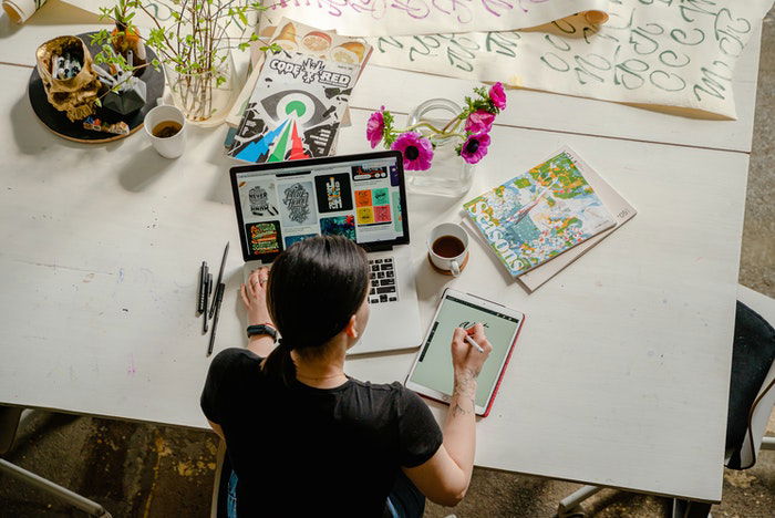 Woman at a desk looking at pictures on her laptop