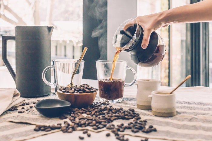 Coffee Splash Photography: photo of a hand pouring hot coffee into a glass mug