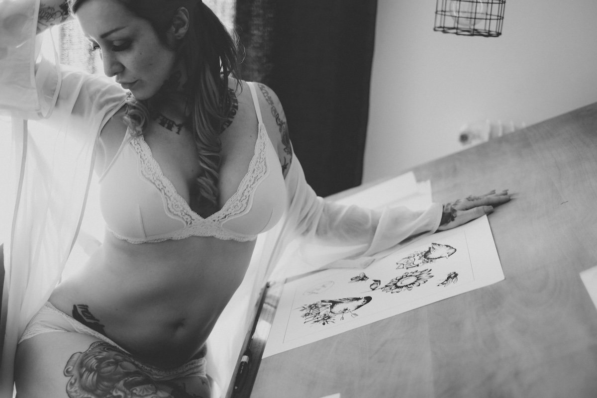 Black-and-white photo of a woman in lingerie posing by a drawing as an example of storytelling for DIY boudoir photos
