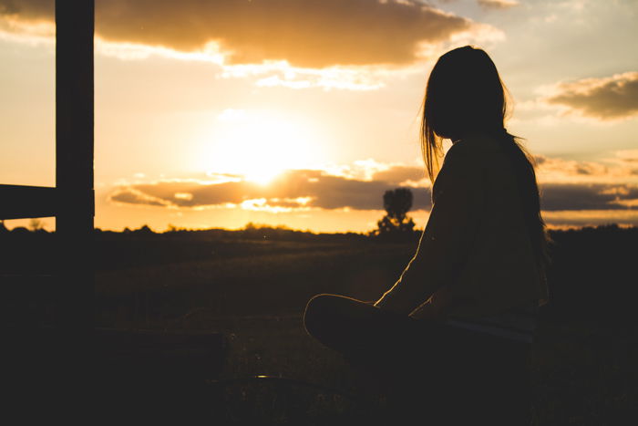 A backlit photo of a female model outdoors