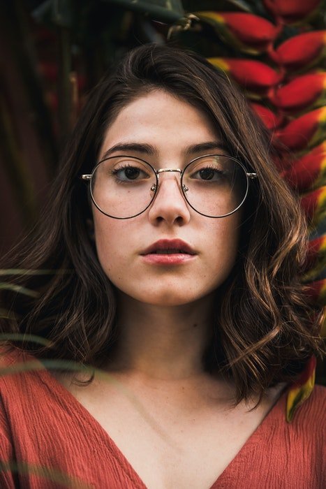 A close up portrait of a young woman in glasses