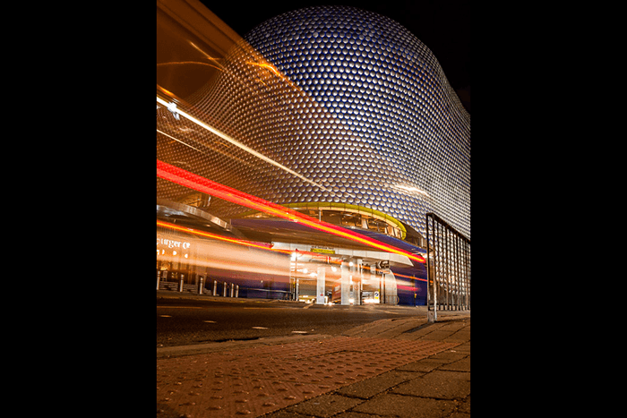 The colored motion blur of light trails in front of the Bullring shopping center in Birmingham United Kingdom