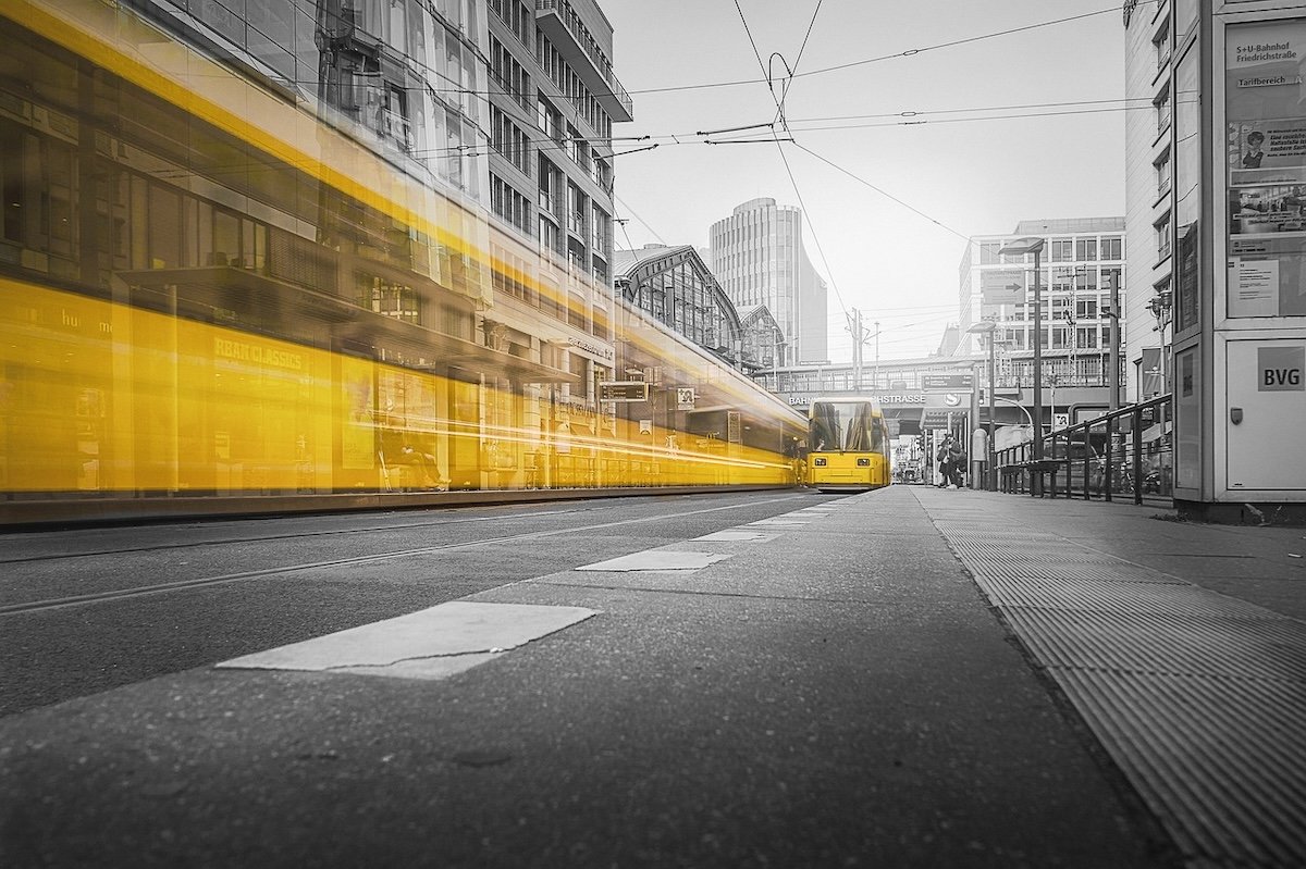 A yellow tram with motion blur and selective color in a black-and-white photo