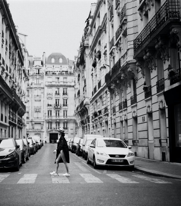Black and white photo of a girl crossing the street