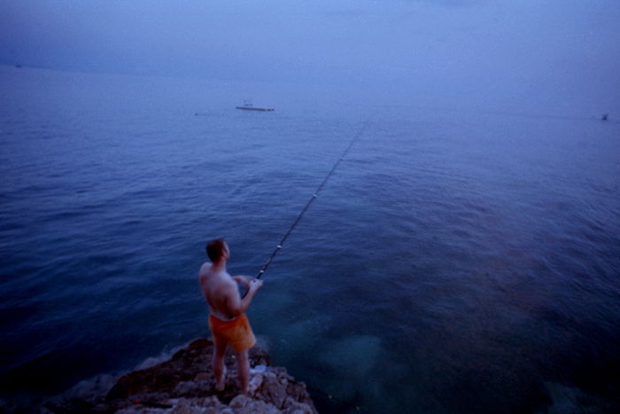 Expired film photo of a man fishing