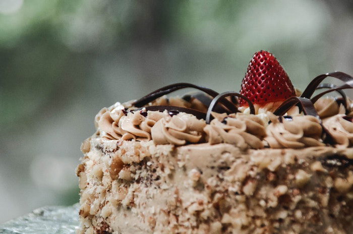 A delicious cake with a strawberry on top creating a focal point