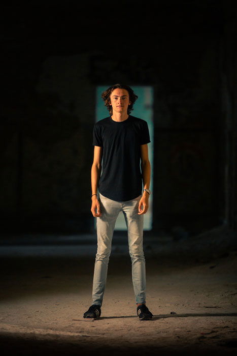 A portrait of a young man standing in a doorway