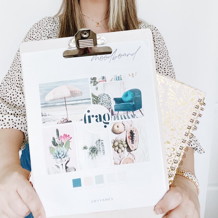A woman holding a clipboard with mood board for interior design