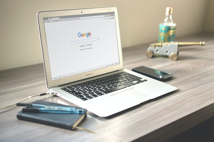 an image of a macbook pro on a table with google on the screen