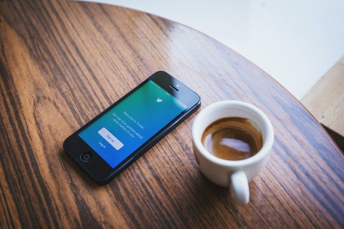 A smartphone and a cup of coffee on a table