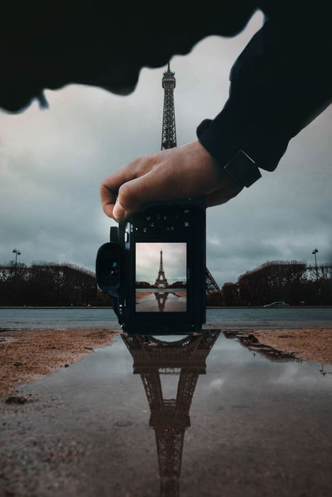 A person taking a photo of the eiffel tower