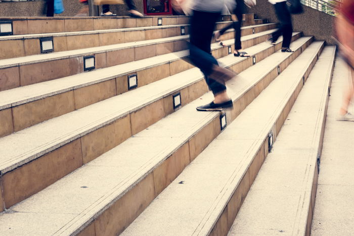 Crowd of people in blurred motion walking up and down the stairs