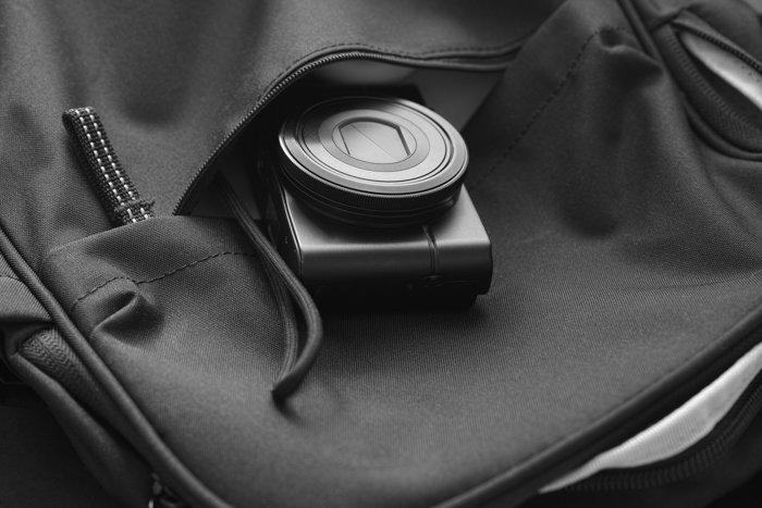 背包里面的紧凑型相机。黑与白。特写。