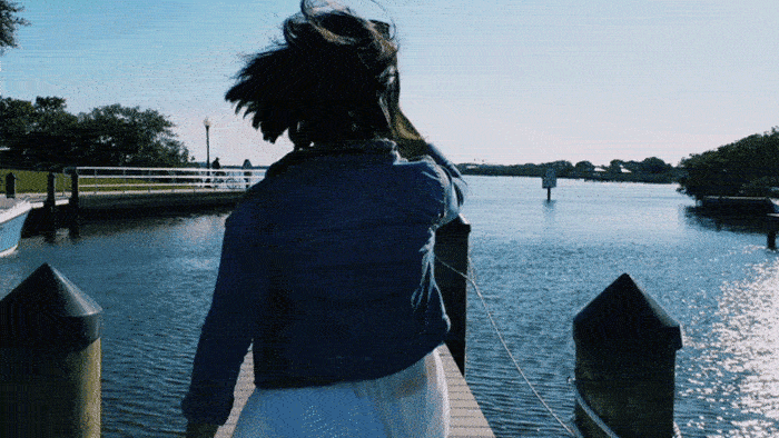 A Gif of a girl walking by a lake