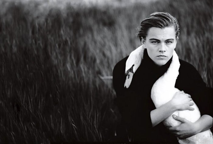 Black and white photo of Leonardo DiCaprio wit a swan around his neck. 