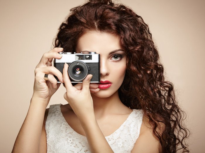 photo of a woman holding a camera over one eye 