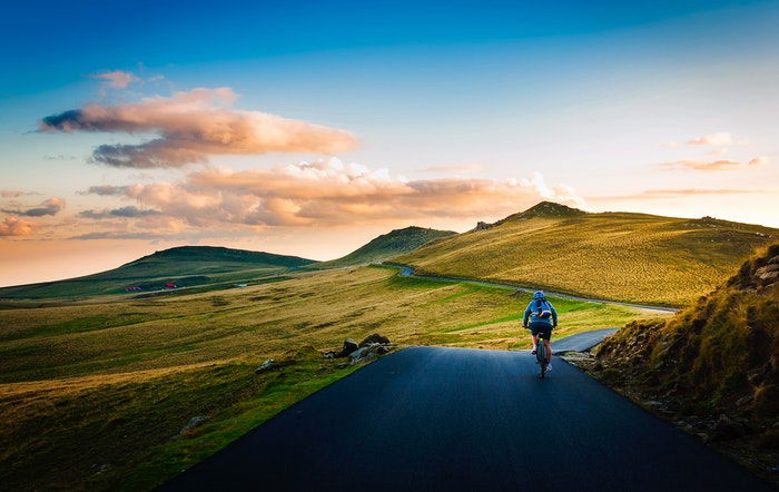 A cyclist on a road in a beautiful countryside area