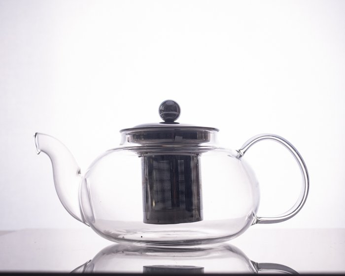 glass teapot with dark metal reflective surface interior