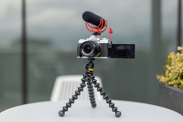 A compact camera on a small tripod.