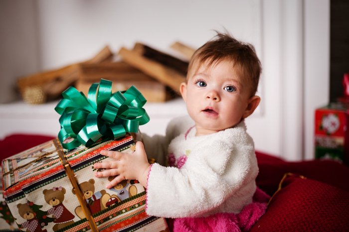 Sweet baby Christmas photo of a little girl with a present