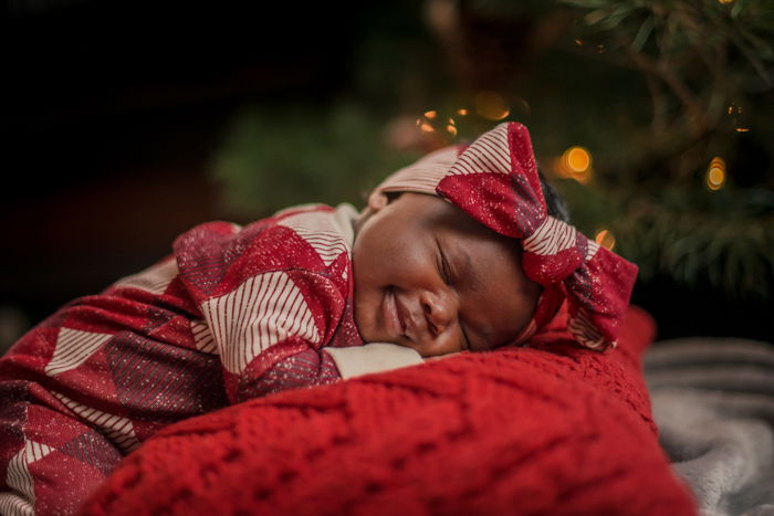 Primeiro retrato de Natal do bebê doce perto da árvore de Natal