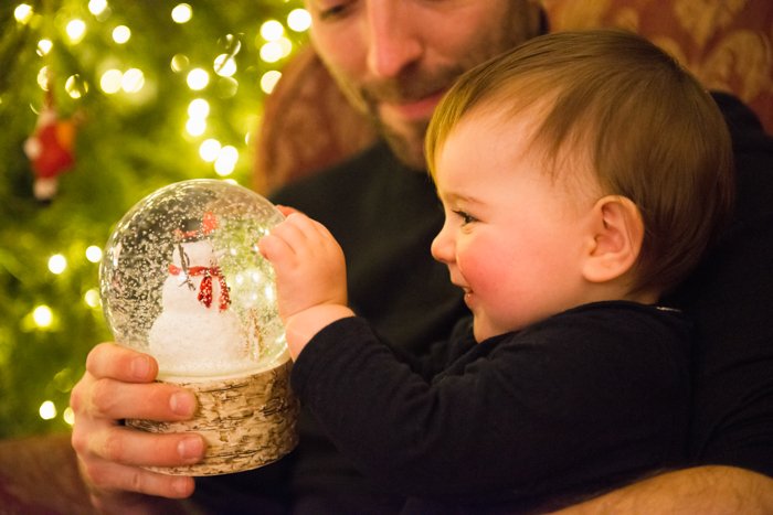 Sweet Christmas photo of a father and baby in front of the christmas tree