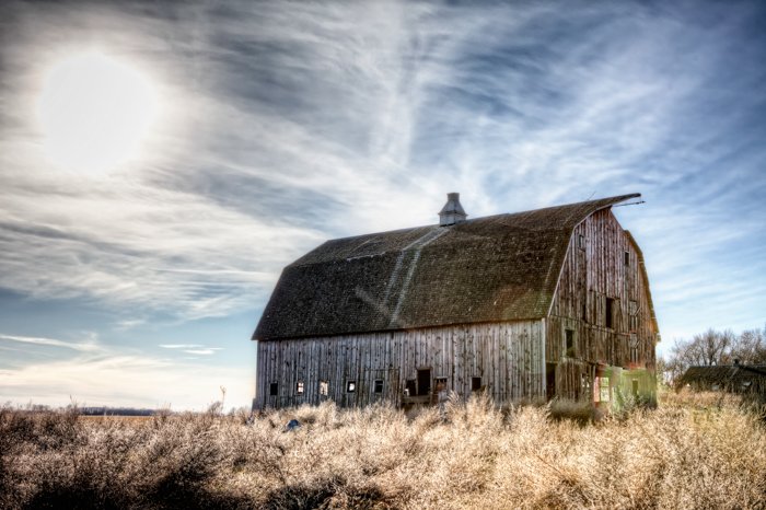 an hdr image of an abandoned barn and winter sky