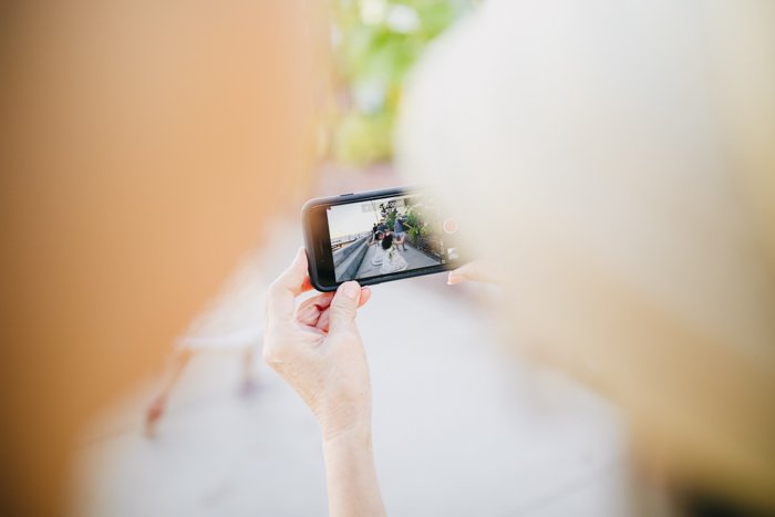 a behind the shoulder shot of a woman holding a smartphone in landscape mode
