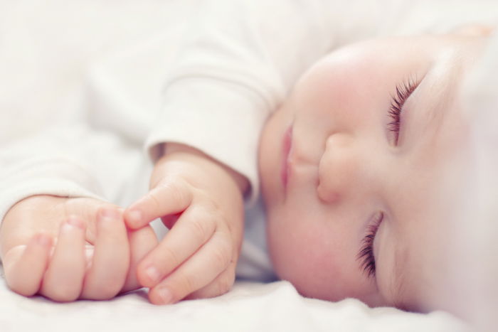 Close-up of baby's hands and face