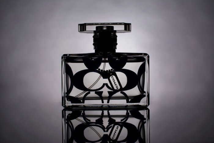 product photography black and white image of a perfume bottle with a reflection and no horizon line