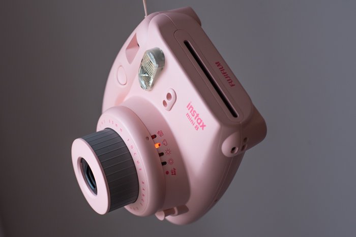 an overhead shot of the light meter on a pink fujifilm instax mini 8 instant film camera