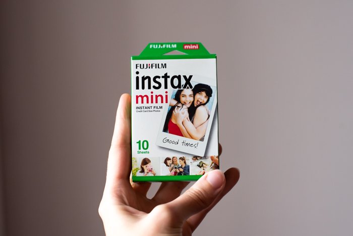 an image of a hand holding up a 10 sheet box of fujifilm instax mini 8 film