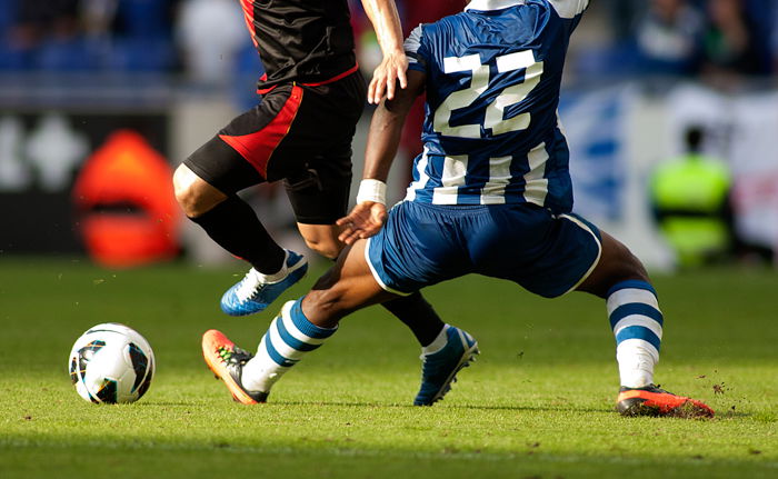 an image of two football players fighting for the ball using a telephoto lens