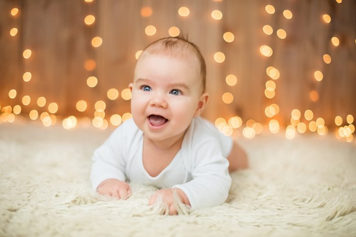Sweet Christmas photo of a baby in front of christmas lights
