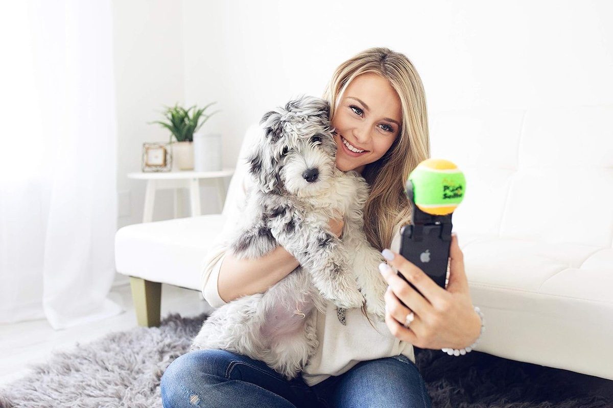 An owner taking a selfie with her dog with a dog picture app